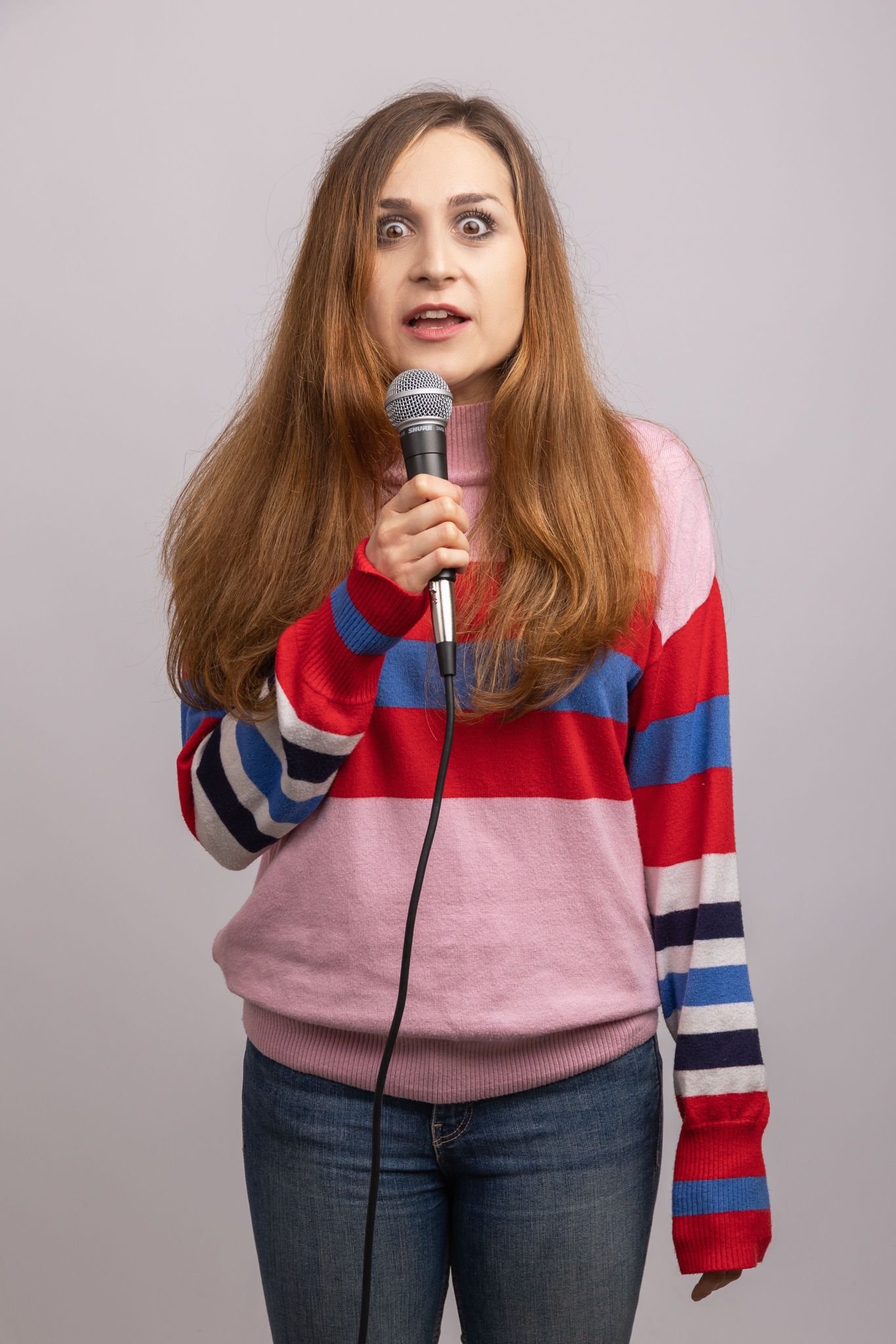 Comedian Hannah Lloyd David performing stand-up with a microphone